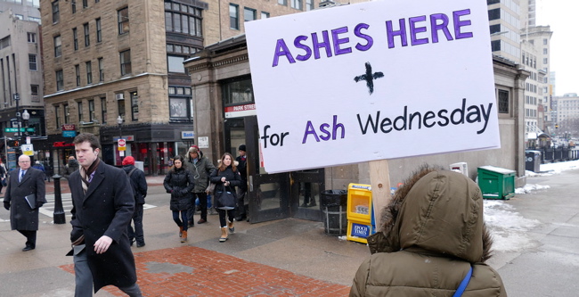 Girl holding sign, 'Ashes here,' on busy city street