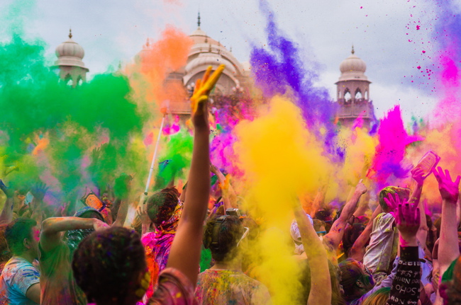 Colored powders in air, crowd below