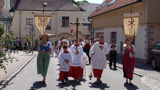 Group of people dressed in traditional clothing walking down street 