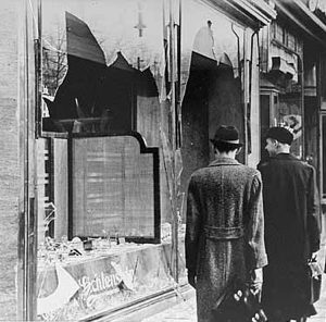 Black-and-white photo of broken windows, two people walking by