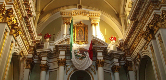 Front of cathedral with pillars and painting of Our Lady of Guadalupe