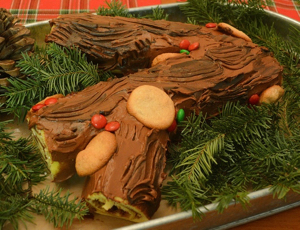 Cake in shape of log in tray with evergreen clippings