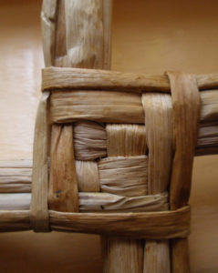 Close-up of square-shaped woven item of thin, straw-type material