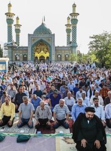 Group of people on knees in front of mosque