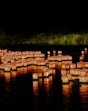 Lit lanterns on water, nighttime