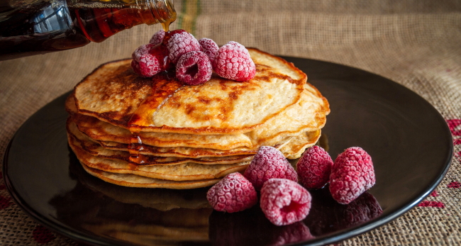 Stack of pancakes on plate with raspberries