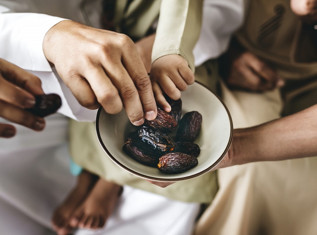 Bowl of dates, hands reaching in