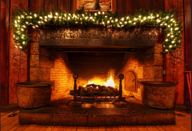 fireplace, lit and decorated with greenery